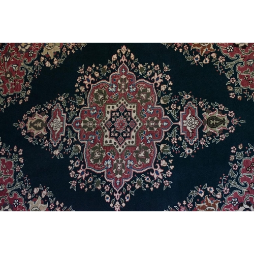 694 - Dark Blue and Pink Ground Rug decorated with flowers and geometric patterns within a cream ground bo... 