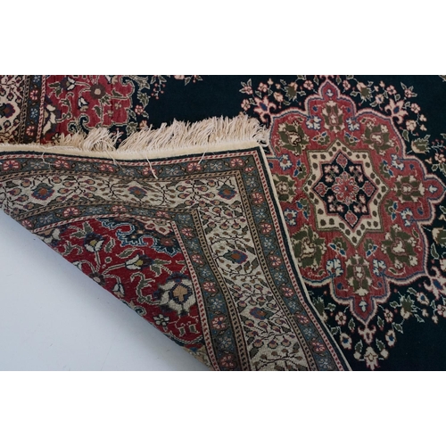 694 - Dark Blue and Pink Ground Rug decorated with flowers and geometric patterns within a cream ground bo... 