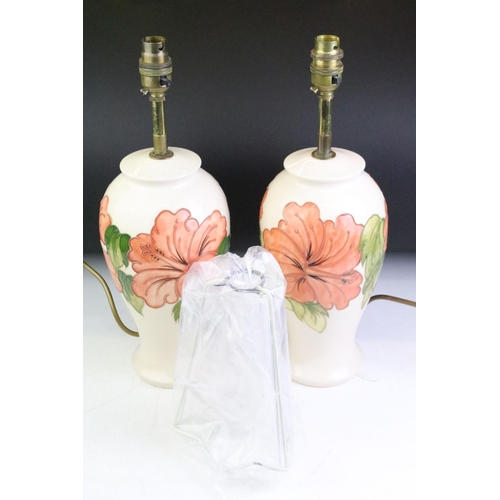 25 - Pair of Moorcroft Hibiscus pattern table lamps, of baluster form, cream ground, approx 38cm tall (in... 