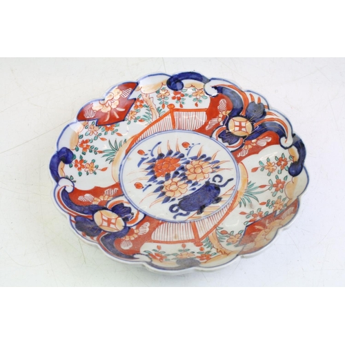 83 - Three 19th Century Japanese Imari plates having blue and white under glazed panelled details and red... 