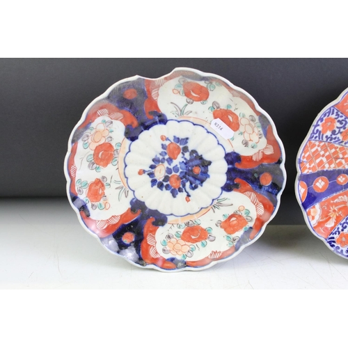 83 - Three 19th Century Japanese Imari plates having blue and white under glazed panelled details and red... 