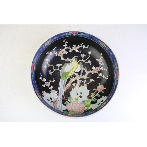 86 - Chinese footed centrepiece bowl having an over glaze enamelled bird perched in a blossom tree to to ... 