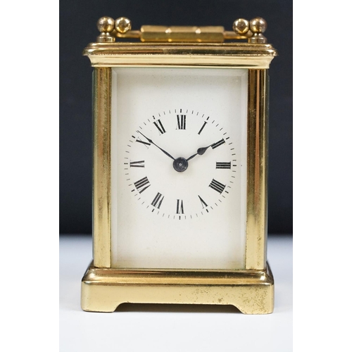 211 - A French brass cased carriage clock with beveled glass panels.