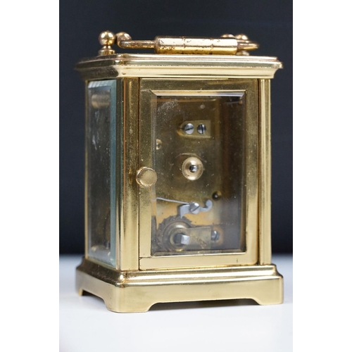 211 - A French brass cased carriage clock with beveled glass panels.