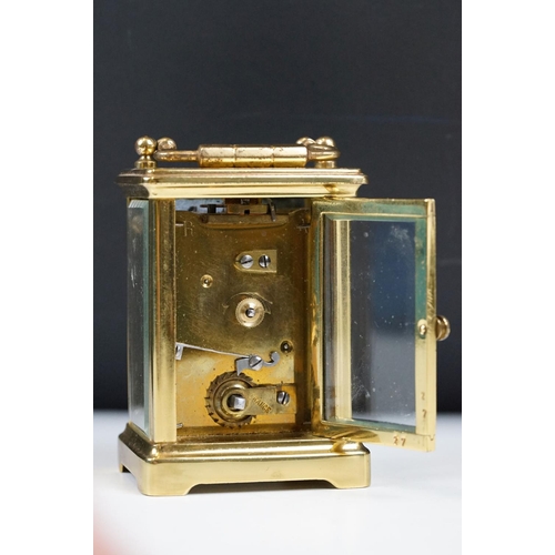 211 - A French brass cased carriage clock with beveled glass panels.