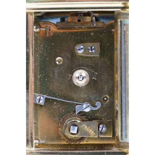 211 - A French brass cased carriage clock with beveled glass panels.