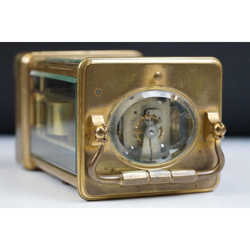 222 - An antique French brass cased carriage clock with beveled glass panels, repeater button to top, reta... 