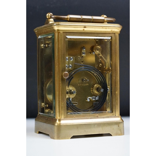 222 - An antique French brass cased carriage clock with beveled glass panels, repeater button to top, reta... 