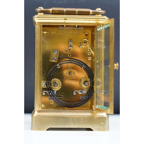 222 - An antique French brass cased carriage clock with beveled glass panels, repeater button to top, reta... 