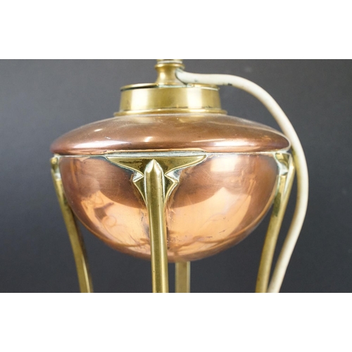 125 - W.A.S. Benson Arts & Craft oil lamp, with a copper font over a brass tri-form base with paw & ball f... 