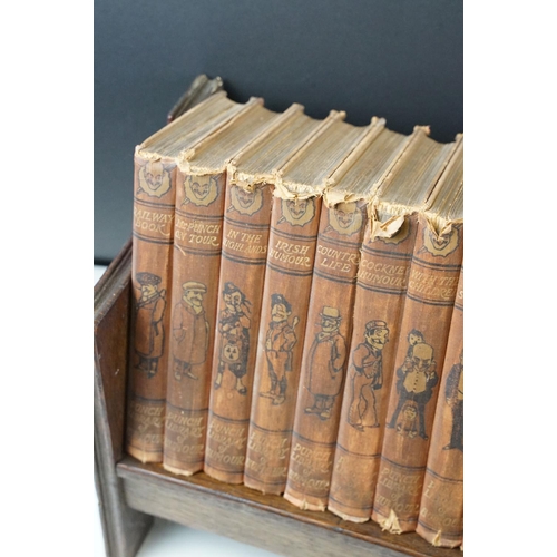 131 - Set of 25 ' Punch Library of Humour ' books, housed on a wooden book trough, approx 64cm wide