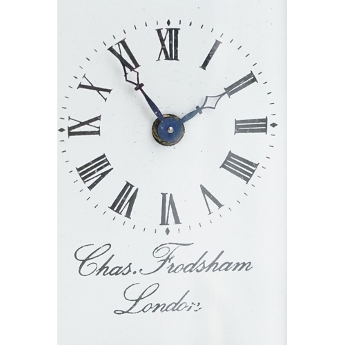 273 - A brass cased carriage clock of oval form with beveled glass panels retailer marked for Chas Frodsha... 