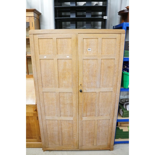 669 - Arts and Crafts ' Heal and Son ' Limed Oak Wardrobe, the two panel doors opening to an interior fitt... 