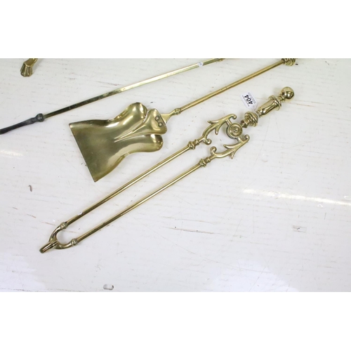 404 - An antique brass fireside companion set to include tongs, shovel and poker together with two piece s... 