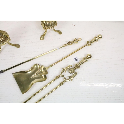 404 - An antique brass fireside companion set to include tongs, shovel and poker together with two piece s... 