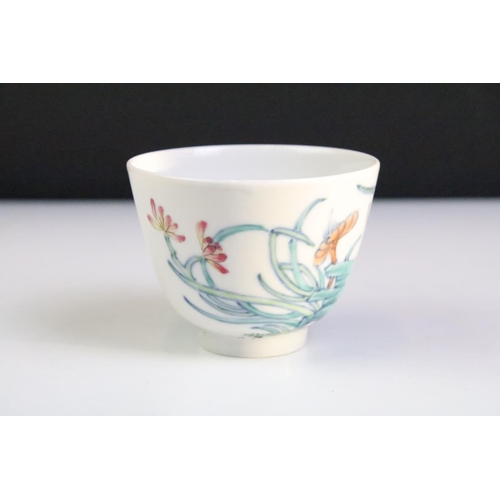 18A - Pair of Chinese porcelain tea bowls with enamel floral & insect decoration, six-character marks to b... 