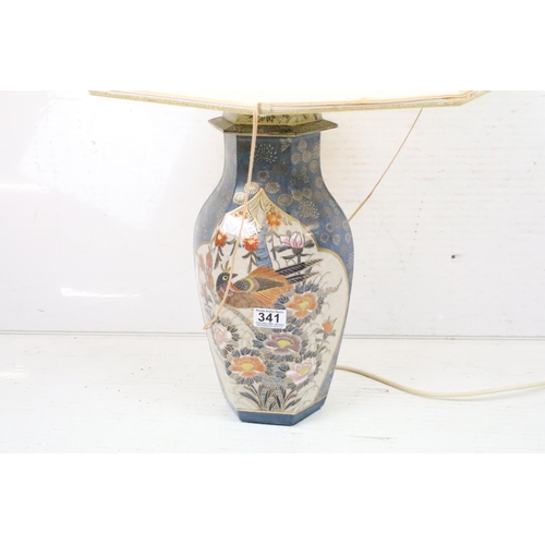 341 - A ceramic oriental style table lamp together with two silver plated candlesticks.