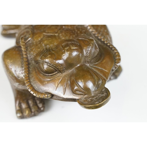 148 - Cast metal Chinese lucky money toad modelled with three legs with moulded detailing and coin to the ... 