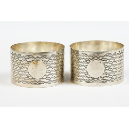 198 - A pair of fully hallmarked sterling silver napkin rings with engine turned decoration, Birmingham 19... 