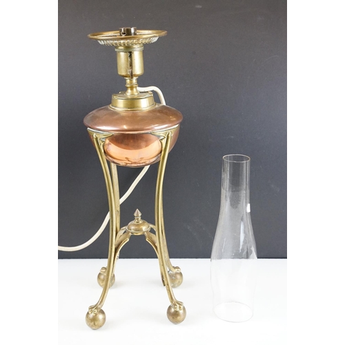 125 - W.A.S. Benson Arts & Craft oil lamp, with a copper font over a brass tri-form base with paw & ball f... 