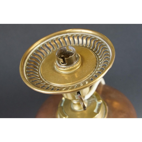 125 - W.A.S. Benson Arts & Craft oil lamp, with a copper font over a brass tri-form base with paw & ball f... 