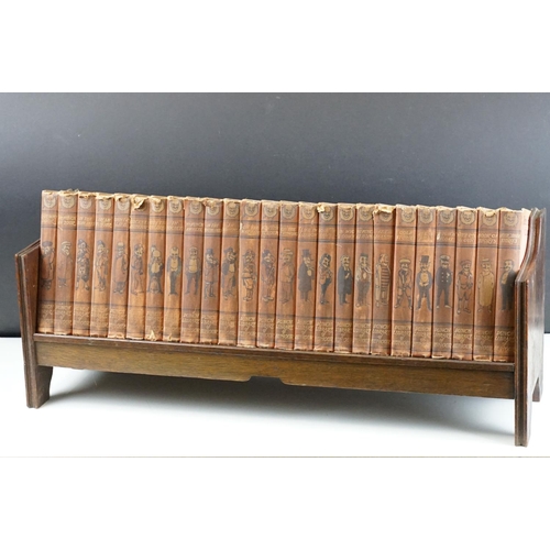 131 - Set of 25 ' Punch Library of Humour ' books, housed on a wooden book trough, approx 64cm wide