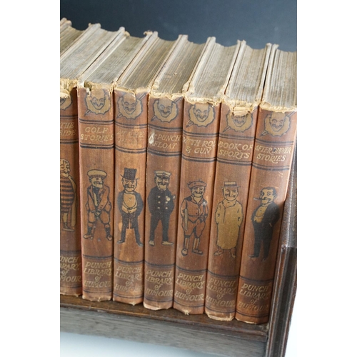 131 - Set of 25 ' Punch Library of Humour ' books, housed on a wooden book trough, approx 64cm wide