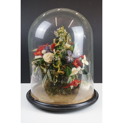 179 - 19th Century Victorian glass dome having a round ebonised wooden base housing a woollen floral displ... 