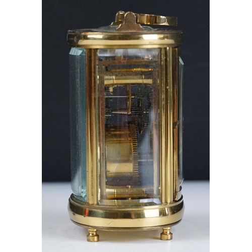 273 - A brass cased carriage clock of oval form with beveled glass panels retailer marked for Chas Frodsha... 