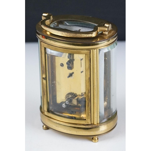 273 - A brass cased carriage clock of oval form with beveled glass panels retailer marked for Chas Frodsha... 