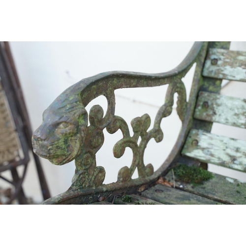 539 - Wooden slatted garden bench, the cast iron ends with lion mask features, approx 125cm wide