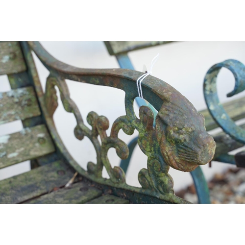 539 - Wooden slatted garden bench, the cast iron ends with lion mask features, approx 125cm wide