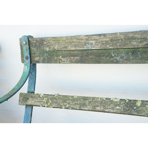 540 - Wooden slatted garden bench with wrought iron scrolling ends, approx 150cm wide