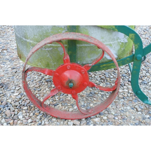 561 - Wrought iron trolley on cast iron wheels, with steel bucket, measures approx 120cm long