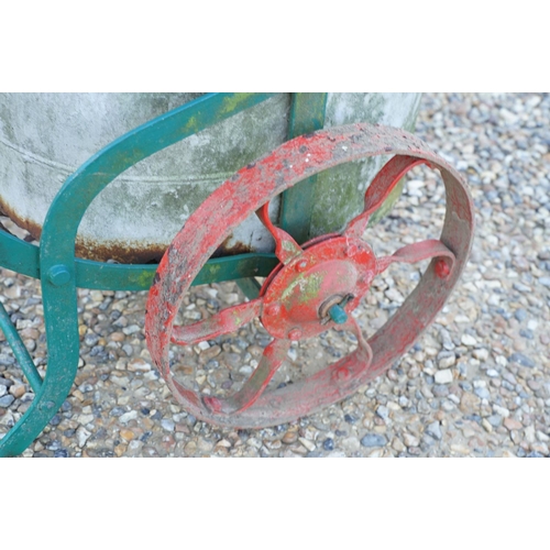 561 - Wrought iron trolley on cast iron wheels, with steel bucket, measures approx 120cm long