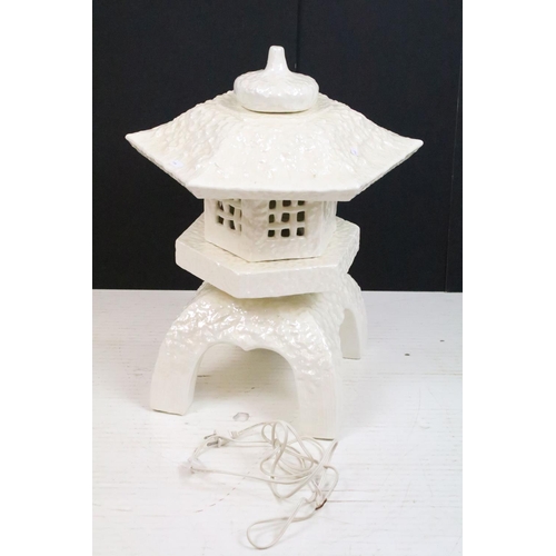 56 - White ceramic table lamp modelled as a pagoda, with lustre finish, raised on four legs, measures app... 