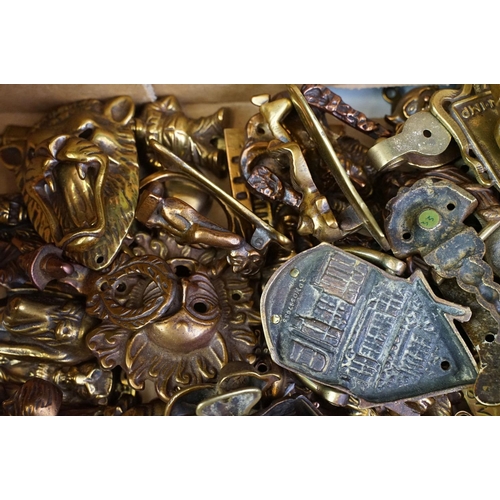 292 - A large collection of brass and copper door knockers to include novelty examples.