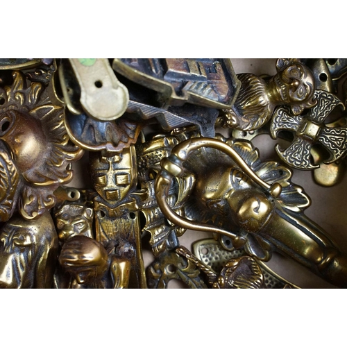 292 - A large collection of brass and copper door knockers to include novelty examples.