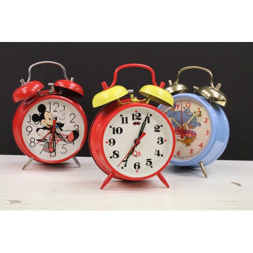 401A - A collection of three vintage wind up alarm clocks to include Micky Mouse and Aladin examples.