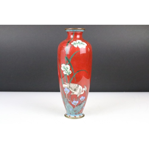 122 - Japanese Cloisonné Vase decorated with a stork amongst flowers on a red ground, 25cm high