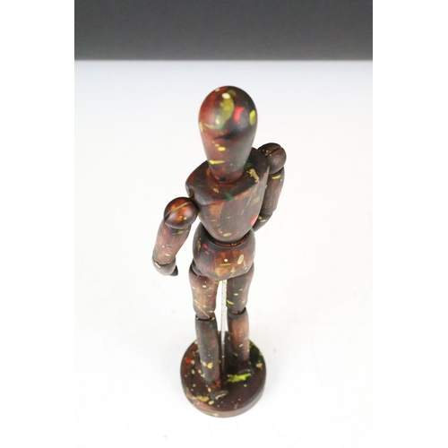 134 - Wooden artists posable drawing aid figure raised on a round wooden base. Measures 33cm tall.