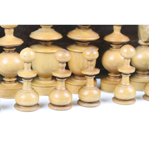 267 - A turned wooden chess set within an antique wooden box, queen stands approx 9cm in height.