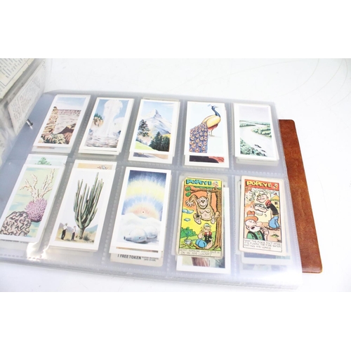 411 - A large collection of cigarette cards contained within four albums to include Players, Black Cat and... 