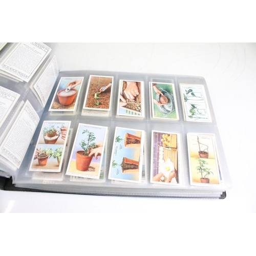 411 - A large collection of cigarette cards contained within four albums to include Players, Black Cat and... 