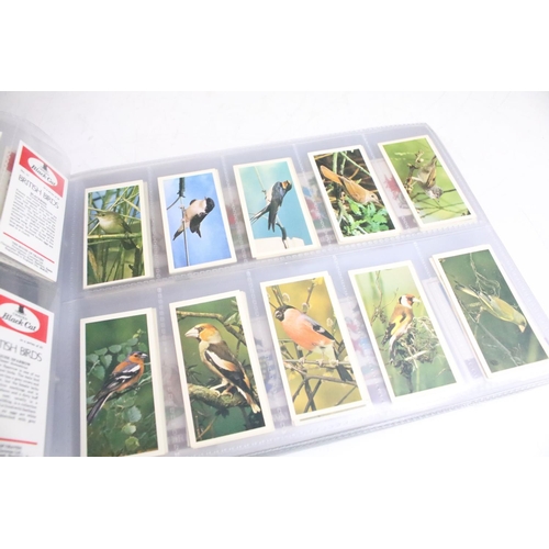 411 - A large collection of cigarette cards contained within four albums to include Players, Black Cat and... 