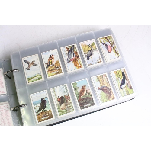 414 - A large collection of cigarette cards within six albums to include Wills, Players, Black Cat, Chings... 