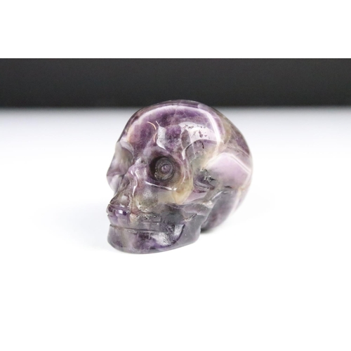 231 - A natural amethyst ornament carved in the form of a human skull, measures approx 4.5cm in length.