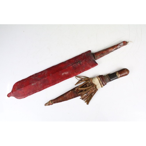 285 - A vintage Kenyan Maasai warriors knife together with a small example.