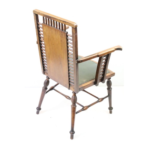 558 - Arts and Crafts style Spindle Back Elbow Chair with studded green leather back and seat raised on tu... 