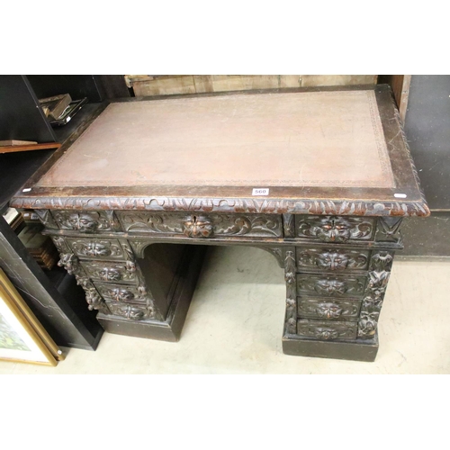 560 - Victorian Carved Dark Oak Desk with brown leather inset top over an arrangement of nine heavily carv... 